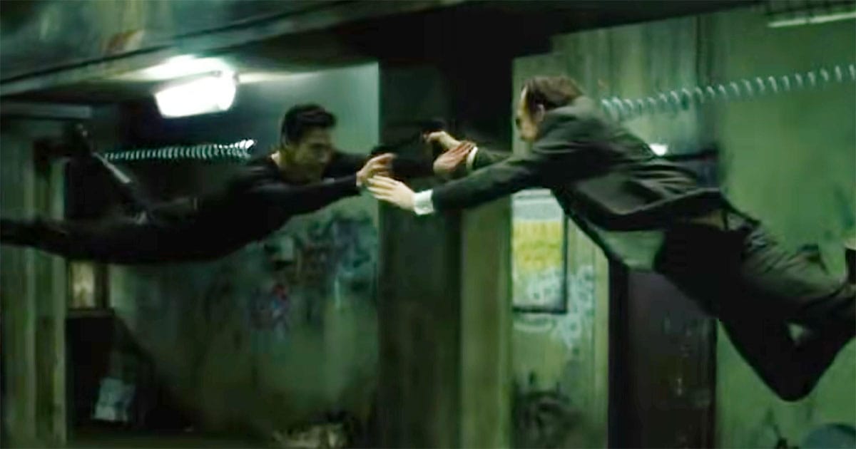Neo collides mid air with Agent Smith in a narrow hallway fight scene from The Matrix, signaling the transition from discovery to direct confrontation.