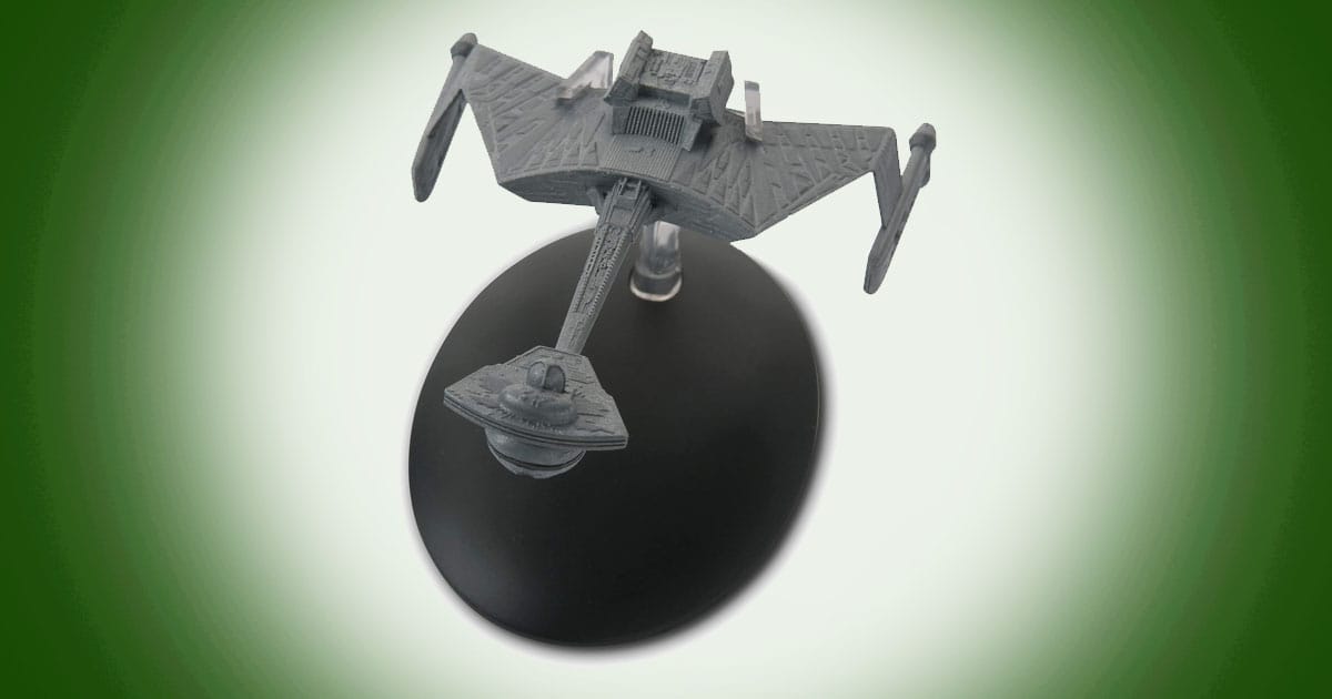 Model of K’t’inga-class Klingon battle cruiser from Star Trek with long forward hull and angular wings mounted on a display stand.