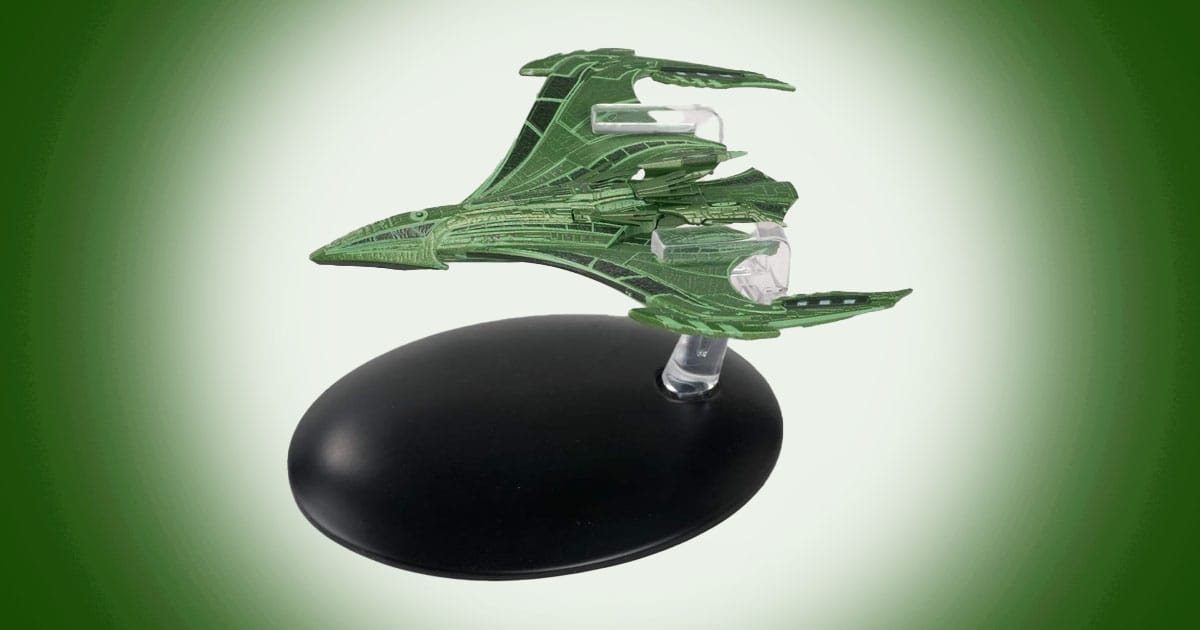 Green model of Romulan Vastam-class Command Warbird from Star Trek with sweeping curved wings and detailed hull mounted on a display stand.