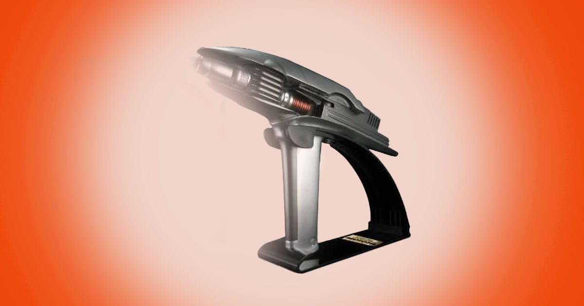 Star Trek Into Darkness phaser prop replica displayed on stand with sleek futuristic design.