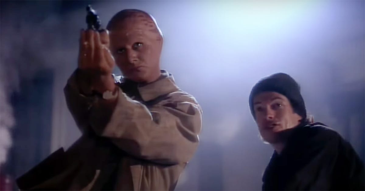 Tenctonese alien detective aiming a gun beside his human partner in a scene from Alien Nation TV series.