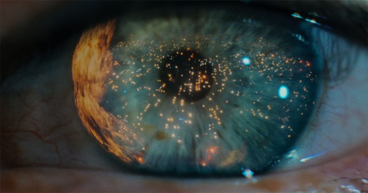 Close-up of an eye reflecting city lights.