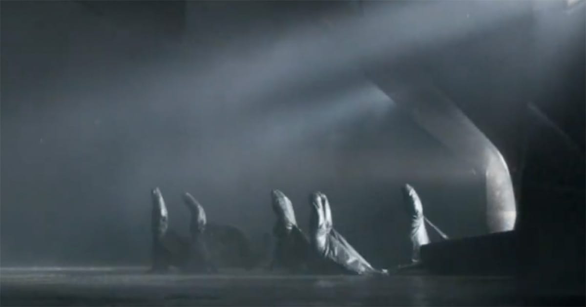 Several cloaked Bene Gesserit sisters process across a dark, misty chamber beneath angled white light.