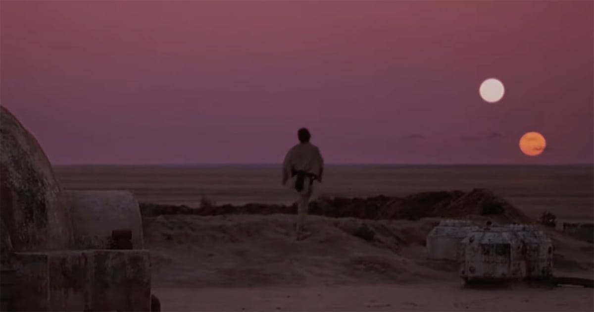 Luke Skywalker watching twin suns set over Tatooine desert in Star Wars Episode IV A New Hope.