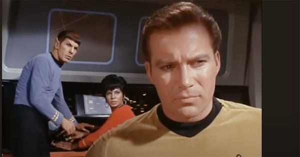 Captain Kirk with Spock and Uhura on the bridge of the Enterprise during a tense moment in Star Trek.