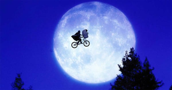 A screen capture from "E.T." with the boy, the bike, and the extra-terrestrial flying in front of a full moon.