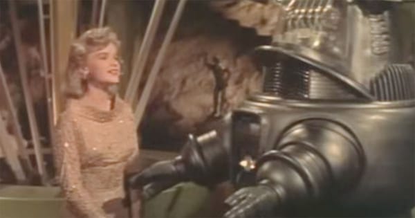 Altaira Morbius speaking with Robby the Robot in the 1956 science fiction classic "Forbidden Planet," exploring themes of technology, ambition, and human nature.