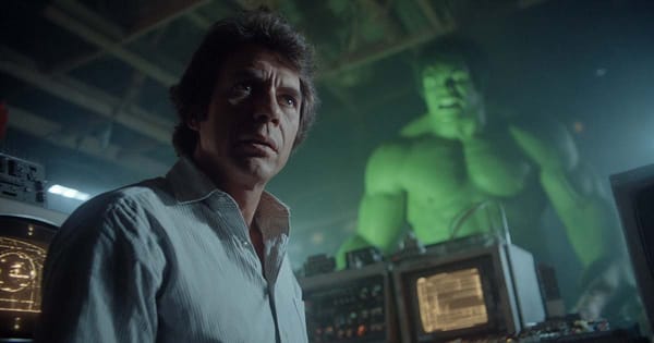 A scientist stands in a dim laboratory as a green, muscular figure looms behind him, symbolizing his transformation and inner conflict.
