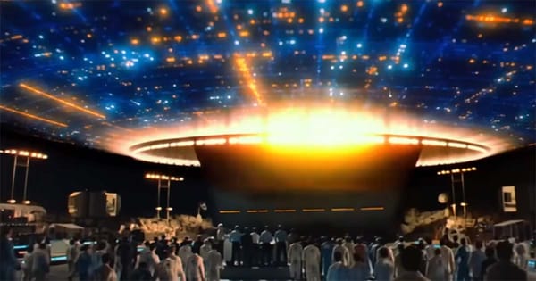 A glowing alien mothership hovers over a crowd of scientists and observers in a night scene from “Close Encounters of the Third Kind.”