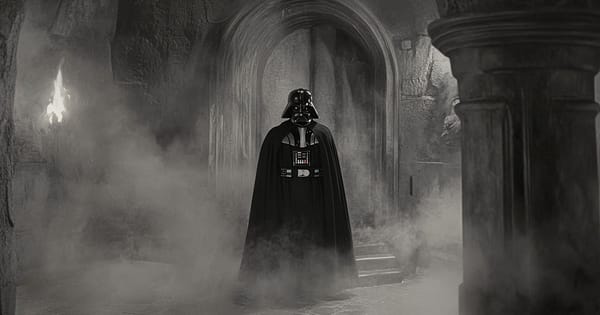 Darth Vader standing alone in black armor and cape inside a stone corridor filled with smoke.