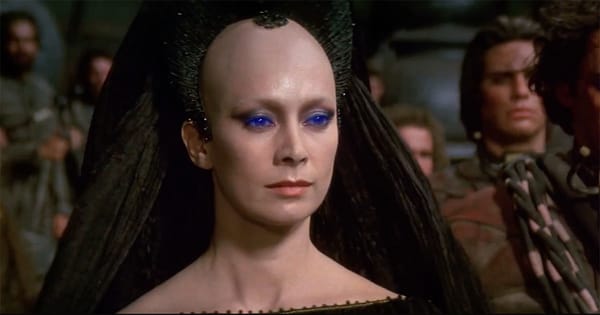 Reverend Mother Gaius Helen Mohiam in Dune 1984, wearing Bene Gesserit robes and blue eye makeup, facing forward with a stern expression.