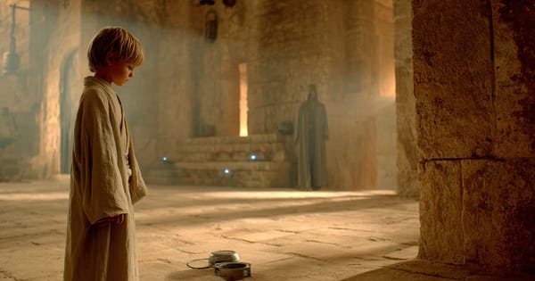 Young child in robes standing in temple with small device on the ground representing Jedi evaluation and midi-chlorian testing in Star Wars.