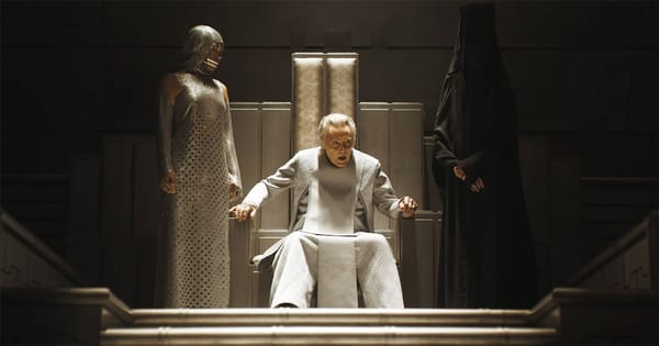 Padishah Emperor Shaddam IV seated on a white throne with attendants standing beside him in an imperial hall.